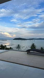 un banco frente a una vista del agua en Sunrise ocean villa, en Phuket