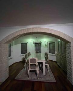 a dining room with a table and chairs and an archway at Peaceful house Velika Kladusa 1km from centre in Velika Kladuša