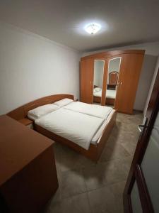 ein kleines Schlafzimmer mit einem Bett und einem Spiegel in der Unterkunft Peaceful house Velika Kladusa 1km from centre in Velika Kladuša