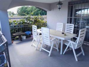 un tavolo bianco e sedie bianche su un balcone di Peaceful house Velika Kladusa 1km from centre a Velika Kladuša