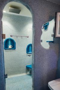 Villa Christa في أريلاز: حمام ذو مقاعد زرقاء ومرحاض في الغرفة