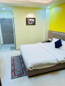 a bedroom with a large white bed and a bathroom at Royal Beach International in Puri