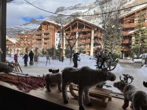 un grupo de animales parados en una cornisa frente a un edificio en Everest Hotel, en Val dʼIsère