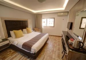 アカバにあるShweiki International Hotelのベッドとテレビがあるホテルの部屋