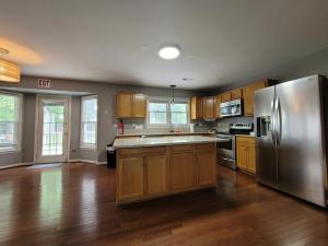 a kitchen with wooden cabinets and a stainless steel refrigerator at Hetten Manor in Woodbridge