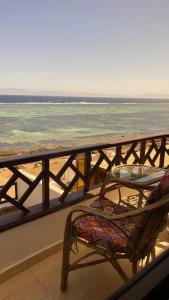 a table and a chair on a balcony overlooking the ocean at Moonlight in Dahab
