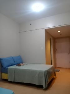 a room with a bed and a blue couch at Sunvida Cebu in Cebu City