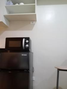 a microwave sitting on top of a refrigerator at Sunvida Cebu in Cebu City
