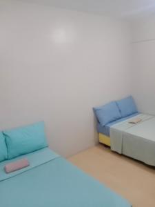 two beds in a room with blue and white at Sunvida Cebu in Cebu City