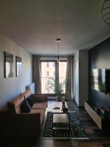 a living room with a couch and a table at Copper Apartment Free Parking in Wrocław