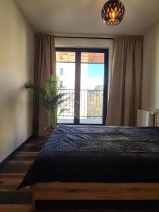a bedroom with a bed and a large window at Copper Apartment Free Parking in Wrocław