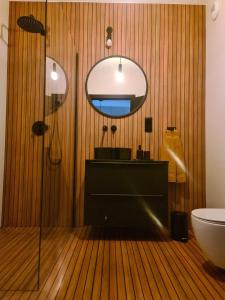 a bathroom with a sink and a mirror and a toilet at Copper Apartment Free Parking in Wrocław