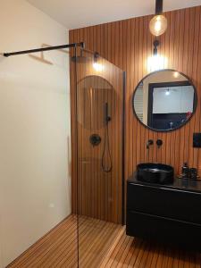 een badkamer met een zwarte wastafel en een spiegel bij Copper Apartment Free Parking in Wrocław