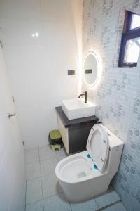 a white bathroom with a toilet and a sink at Balay Greenika Tagyatay Private Pool in Tagaytay