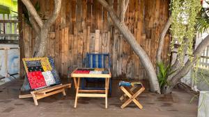 ラン島にあるSawaddeethaweesuk At Kohlarnの木製の壁の前に椅子2脚とテーブル