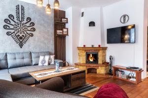 sala de estar con sofá y chimenea en TatryTOP Apartamenty Kaszelewski, en Zakopane