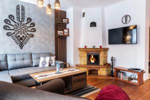 a living room with a couch and a fireplace at TatryTOP Apartamenty Kaszelewski in Zakopane