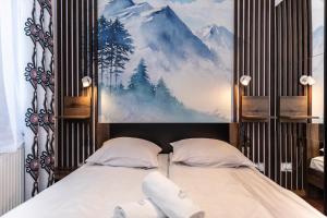 a bedroom with two beds and a painting on the wall at TatryTOP Apartamenty Kaszelewski in Zakopane