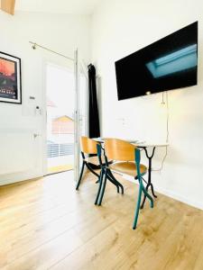 einen Schreibtisch mit Stuhl und einen TV an der Wand in der Unterkunft Studio ideal deplacement pro tourisme et mariage Parking gratuit in Chapareillan
