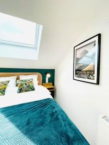 a bedroom with a bed and a picture on the wall at Studio ideal deplacement pro tourisme et mariage Parking gratuit in Chapareillan