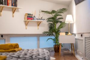 een slaapkamer met een bed en een plant en een lamp bij Studio Apartment LION Portorose in Portorož