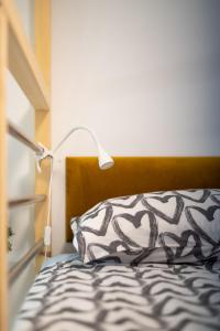 een bed met een zwart-wit kussen en een lamp bij Studio Apartment LION Portorose in Portorož