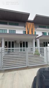a white fence in front of a building at Bonda Lilik Homestay in Klang