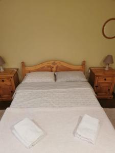 sypialnia z łóżkiem z białą pościelą i 2 szafkami nocnymi w obiekcie Apartament Mariuca w mieście Gura Humorului