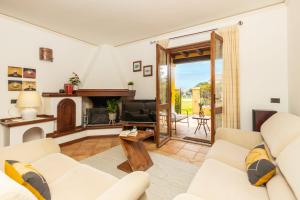 a living room with white furniture and a fireplace at Casa il grande Carrubo in Santa Maria Navarrese