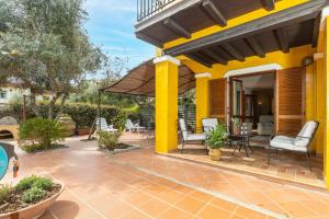 a patio with chairs and an umbrella on a house at Casa il grande Carrubo in Santa Maria Navarrese