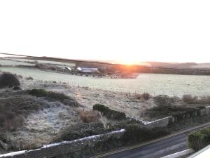 uma vista de Inverno para um campo e uma estrada em Woodlands em Southerndown