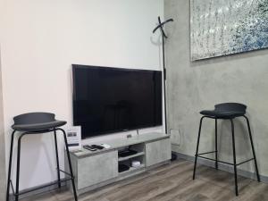 Apartment Udine في أوديني: اثنين من المقاعد السوداء في غرفة المعيشة مع التلفزيون