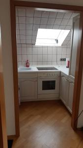uma cozinha com um lavatório e um fogão forno superior em FeWo H Reußwig em Nidda