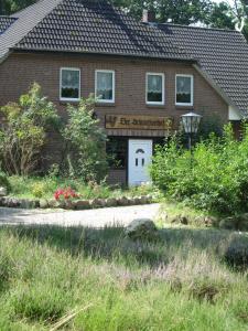 une maison avec un garage blanc muni d'un panneau. dans l'établissement Der Schnuckenhof, à Schneverdingen
