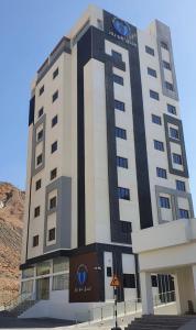 un edificio con un cartel en la parte delantera en Blue Rose Hotel en Al Amarat