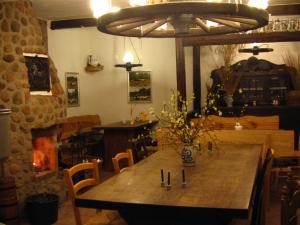 une salle à manger avec une table en bois et une cheminée dans l'établissement Der Schnuckenhof, à Schneverdingen