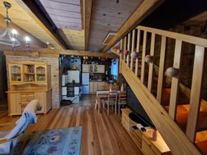 a living room with a staircase and a kitchen at Domki Brenna Leśnica chatka ze spa in Brenna