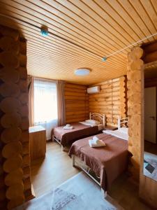 una camera con tre letti in una baita di tronchi di Eco hotel & restaurant "SKALA" a Borovoye