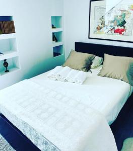 1 cama con sábanas blancas y almohadas en una habitación en Douro Box en Castelo de Paiva