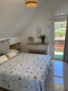 een slaapkamer met een bed en een raam bij Au coeur du sud in Saint-Joseph