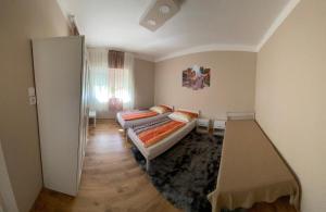 Cette petite chambre comprend deux lits et un couloir. dans l'établissement Edina apartman, à Balatonlelle