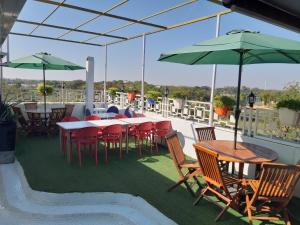 a patio with tables and chairs and umbrellas at Hotel The Grand Piano - Best Business Hotel in Patan in Pātan