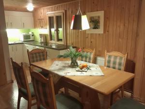 a kitchen with a wooden table and chairs with a table and a table at Haus Silke in Silbertal