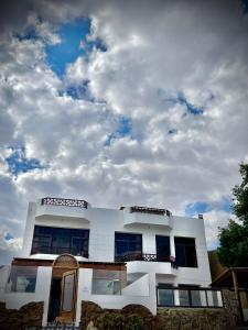 une maison blanche avec un ciel nuageux en arrière-plan dans l'établissement Moonlight, à Dahab