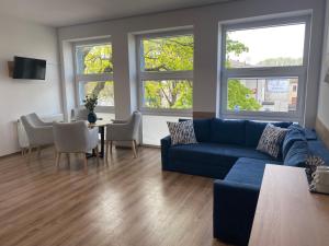 uma sala de estar com um sofá azul e uma mesa em Apartamenty Cechowianka Ustka em Ustka