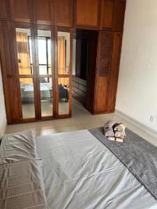 1 dormitorio con 1 cama y 2 zapatillas en el suelo en Apartamento em frente à praia Barra da Tijuca, en Río de Janeiro