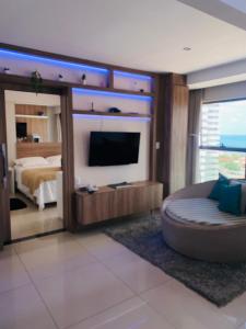 1 dormitorio con 1 cama, TV y sofá en Apartamento Duplex Vista Mar em Natal, en Natal