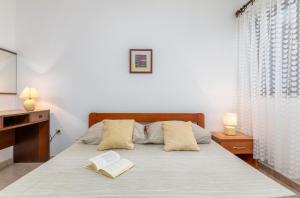 Apartment Luana A2 في فاجانا: غرفة نوم بها سرير وكتبين عليها