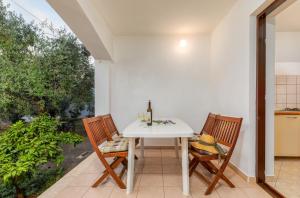 una mesa blanca y sillas en una cocina con ventana en Apartment Luana A2 en Fažana