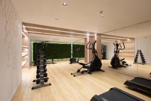 un gimnasio con cintas de correr, elípticas y espejo en LUX&EASY Athens Metro Suites, en Atenas